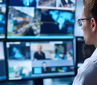 une homme devant des &eacute;crans de contr&ocirc;le